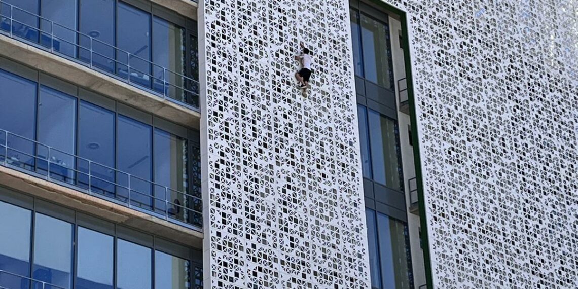 Un hombre escala la fachada del ayuntamiento de Estepona de siete plantas de altura