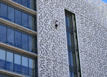 Un hombre escala la fachada del ayuntamiento de Estepona de siete plantas de altura