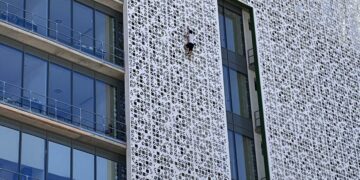 Un hombre escala la fachada del ayuntamiento de Estepona de siete plantas de altura